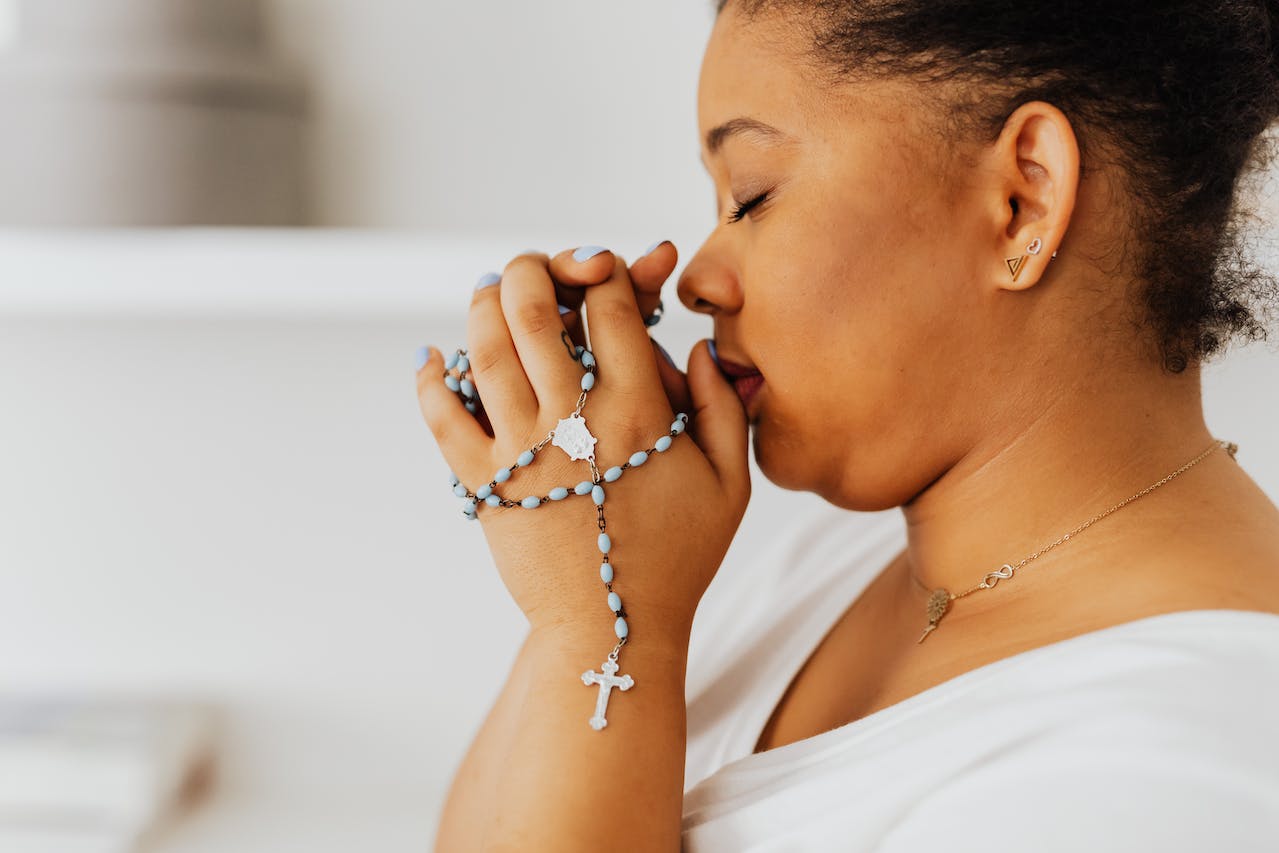 Woman Holding a Rosary while Praying