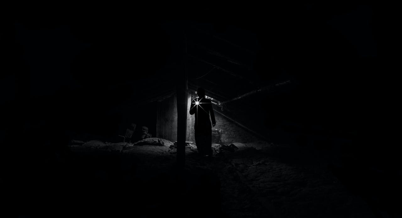 Low Angle View of Man Standing at Night While Holding Light