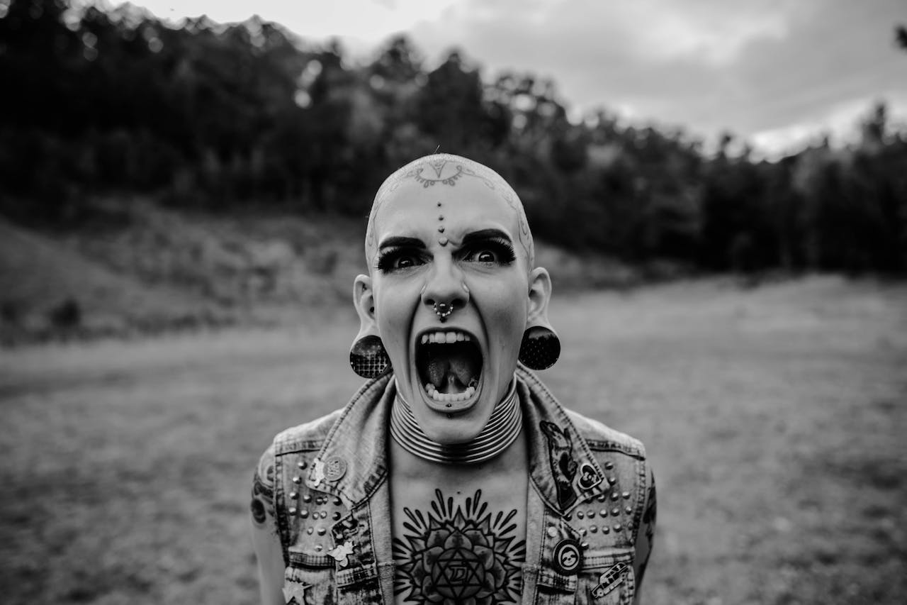 Portrait of Bald Woman with Tattoos Screaming