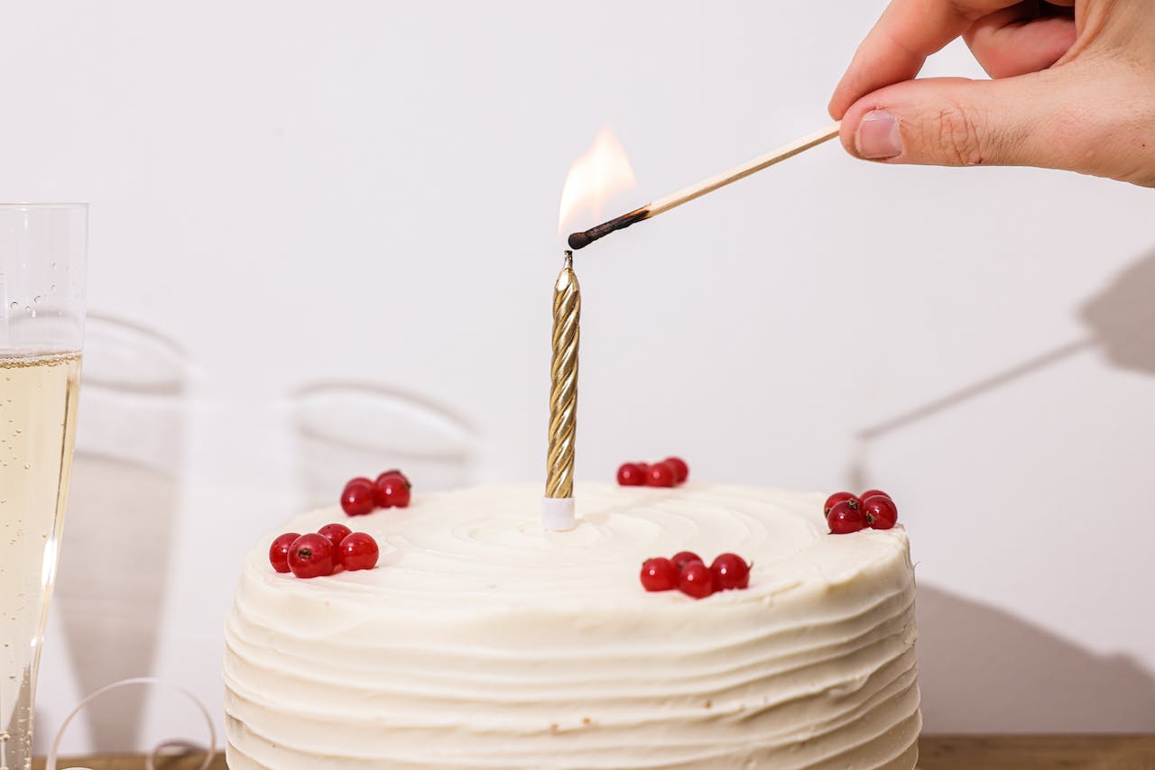 A Person Lighting the Candle on a Cake
