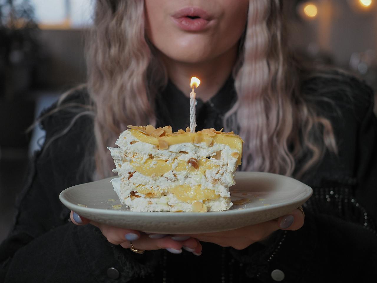 Woman Blowing Out a Candle from a Birthday Cake