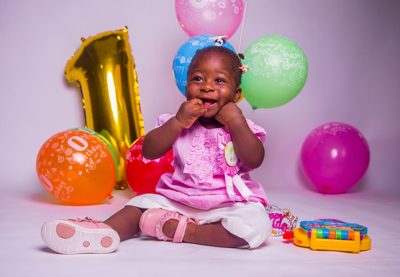 Baby Girl Sitting on Floor With Balloons