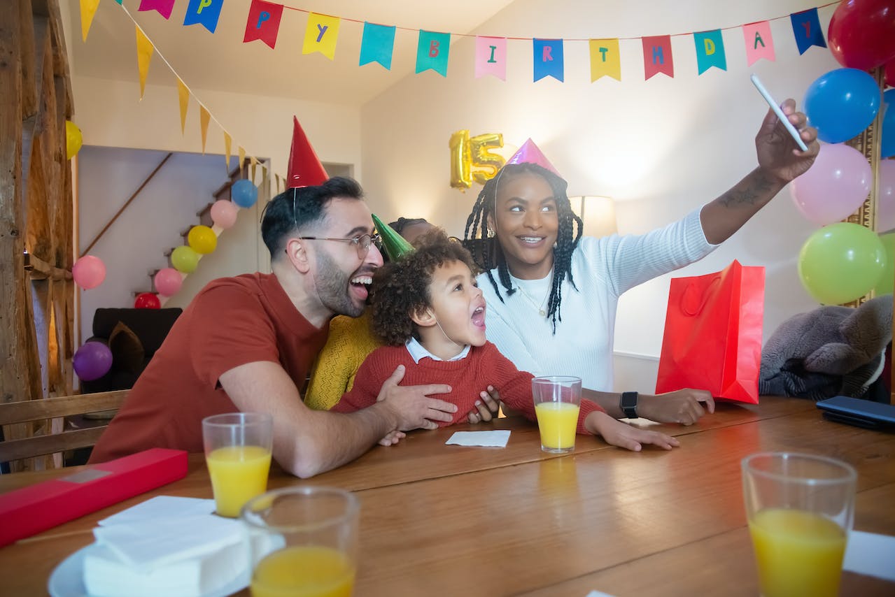 A Family with Party Hats Taking a Groupfie