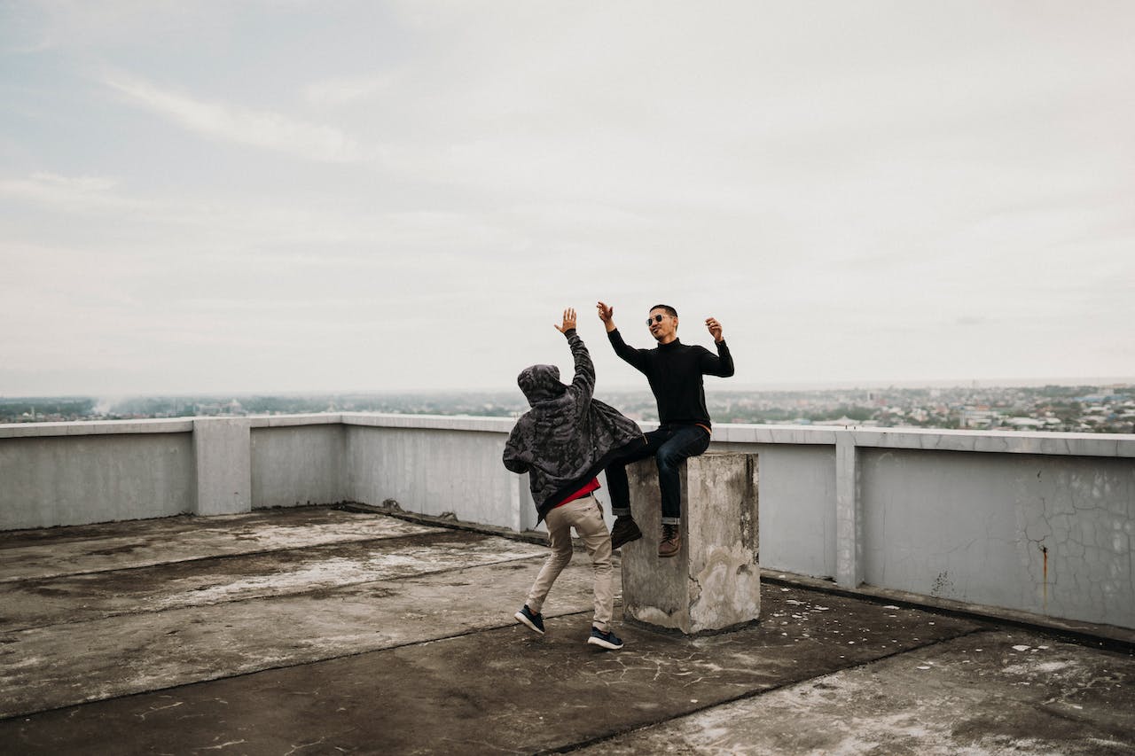 Two Men Doing a High Five on a Rooftop
