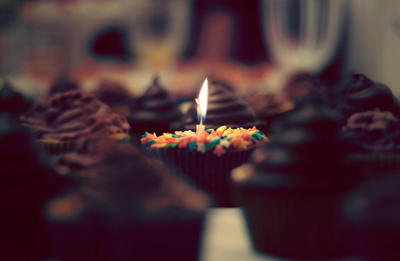 Burning Candle With Cupcake on Table