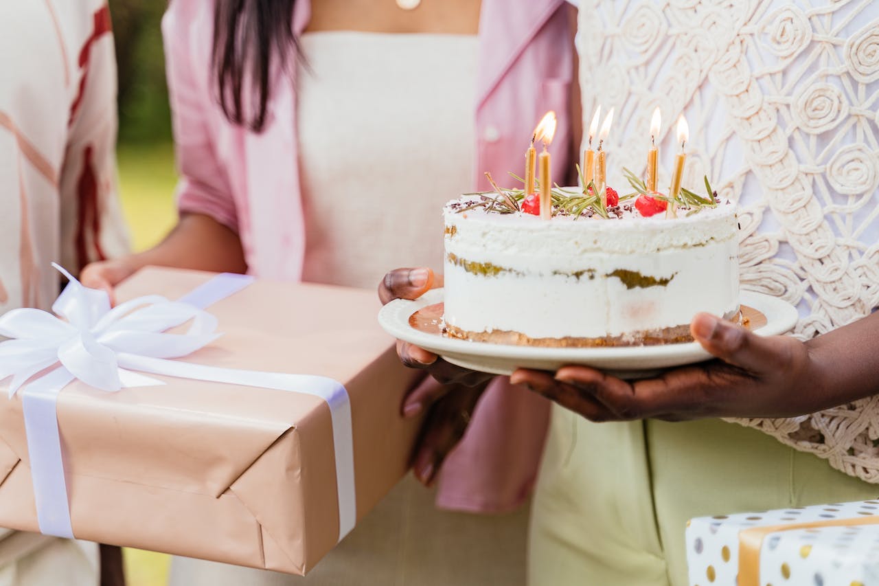 Women Holding Birthday Cake and Present